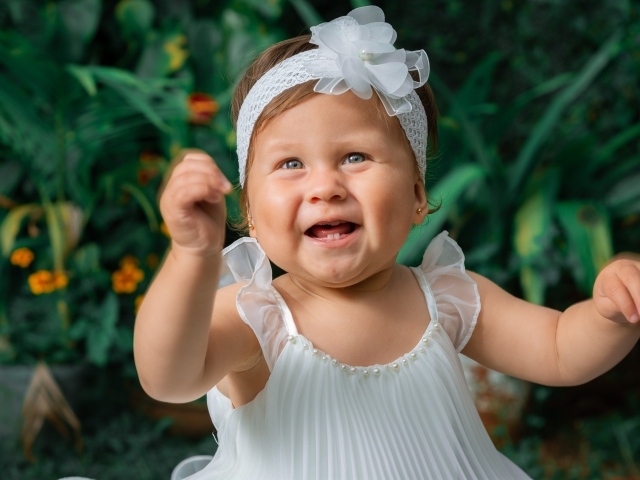 Красивая маленькая девочка в белом платье 