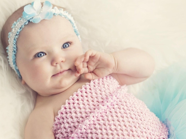 Голубоглазая маленькая девочка с повязкой на голове 