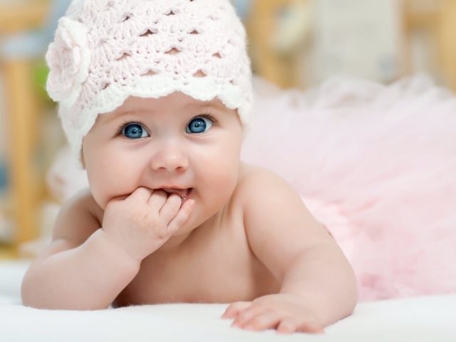 Милая голубоглазая малышка в розовой шапке 