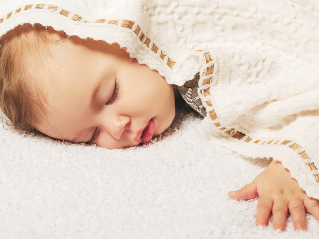 Милый спящий ребенок под покрывалом 