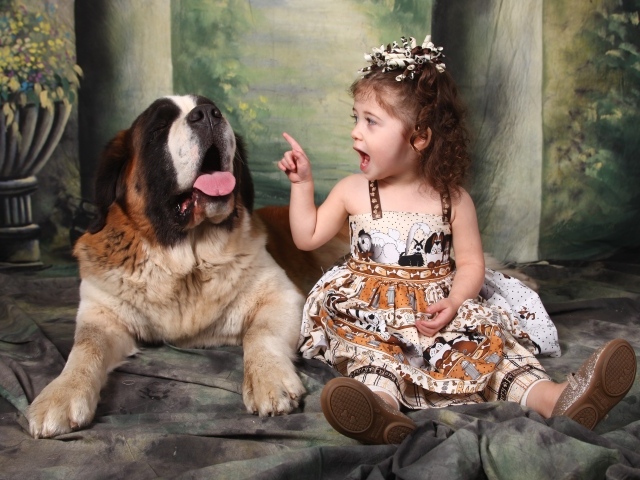 Маленькая красивая девочка с собакой породы сенбернар