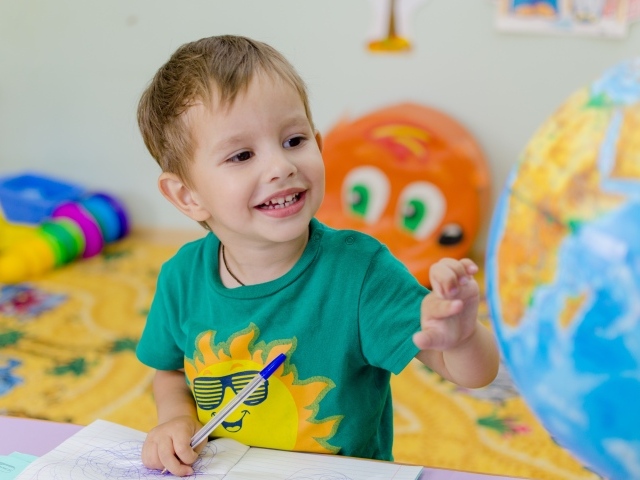 Маленький мальчик изучает глобус 