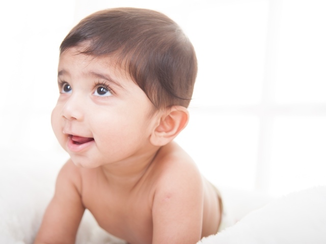 Маленький кареглазый мальчик на белом фоне 