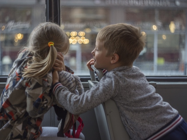Маленькие девочка и мальчик сидят в автобусе 