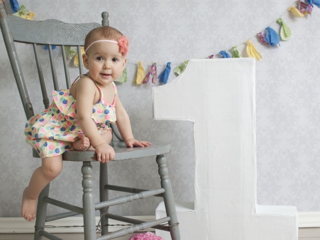 Маленькая девочка в платье на стуле
