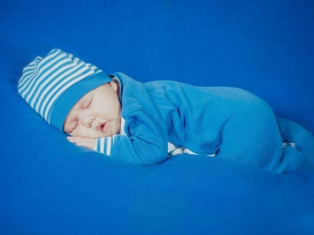 Спящий грудной ребенок в голубом костюме 