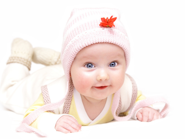 Улыбающийся голубоглазый ребенок в шапке 