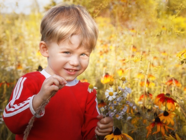 Улыбающийся голубоглазый мальчик с полевыми цветами 