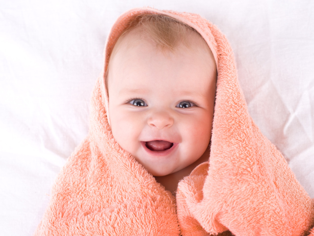 Улыбающийся грудной ребенок в полотенце