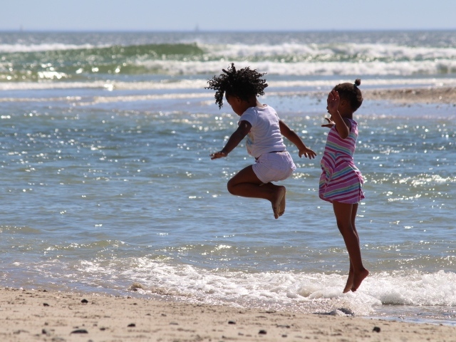 Две маленькие девочки играют на морском берегу