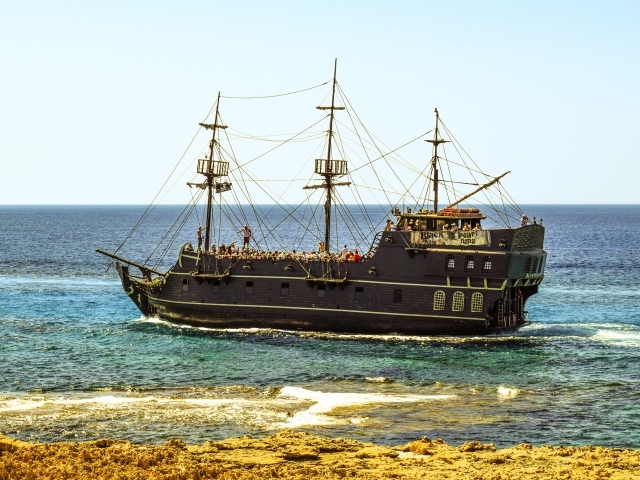 Большой черный пиратский корабль у берега