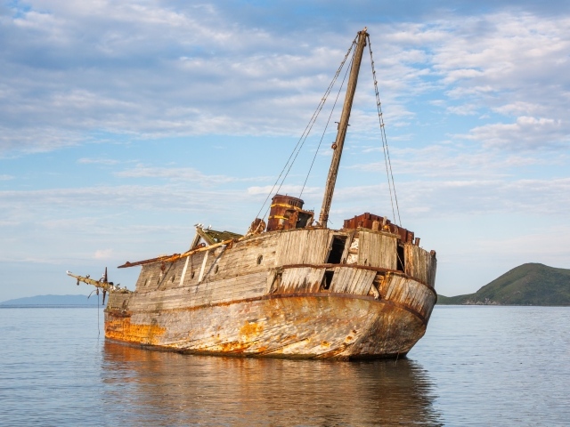 Старый разрушенный корабль на берегу 