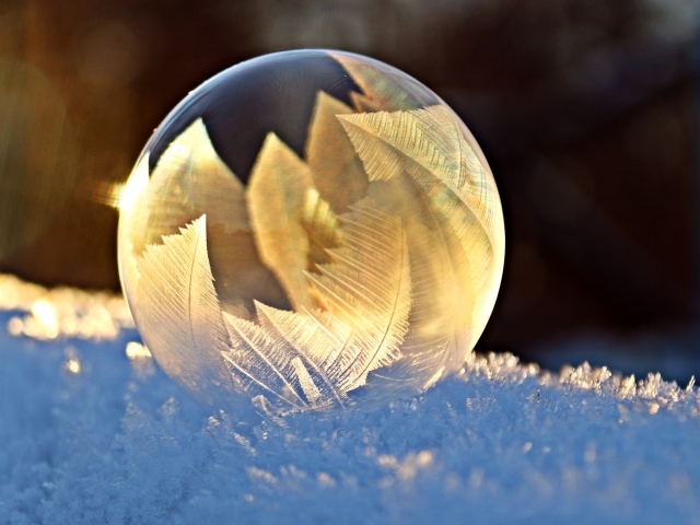 Красивый морозный рисунок на мыльном пузыре на снегу