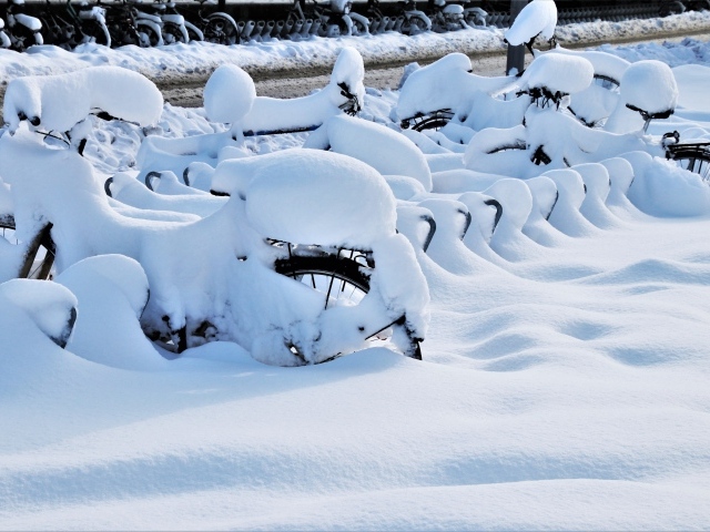 Велосипеды в снегу зимой на стоянке 