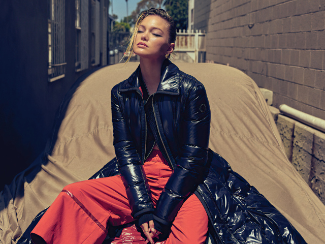 Актриса Оливия Холт в черной куртке сидит на машине