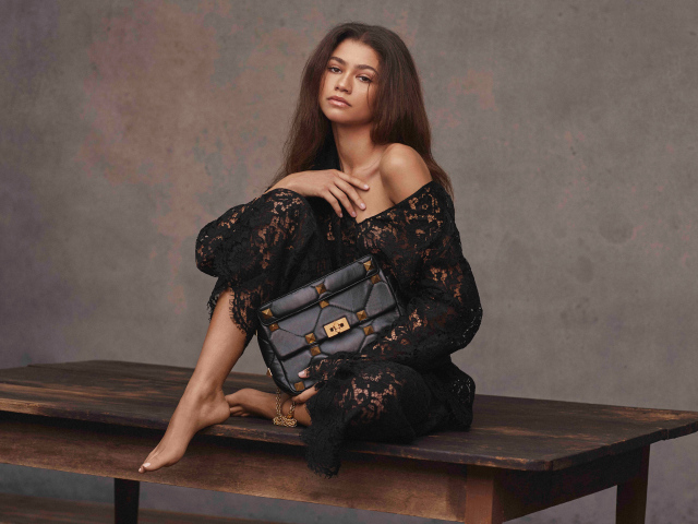 Американская актриса и певица Зендая в черном платье на столе