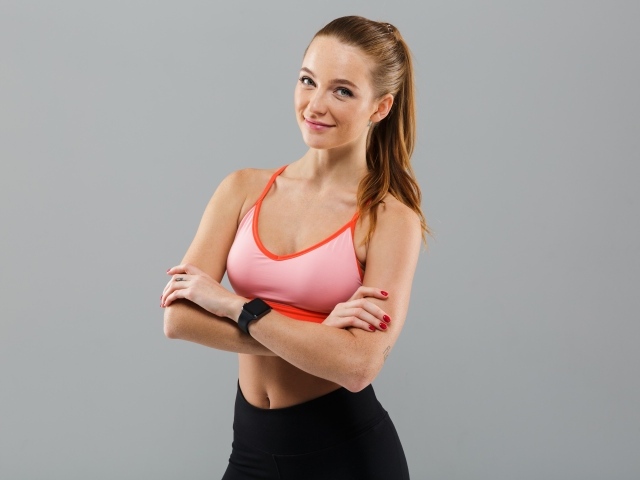 Красивая девушка в топике на сером фоне 