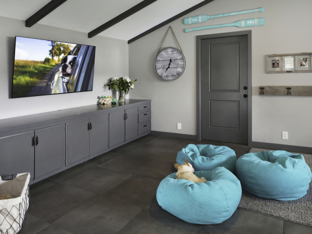 Голубые кресла в комнате с большим телевизором 