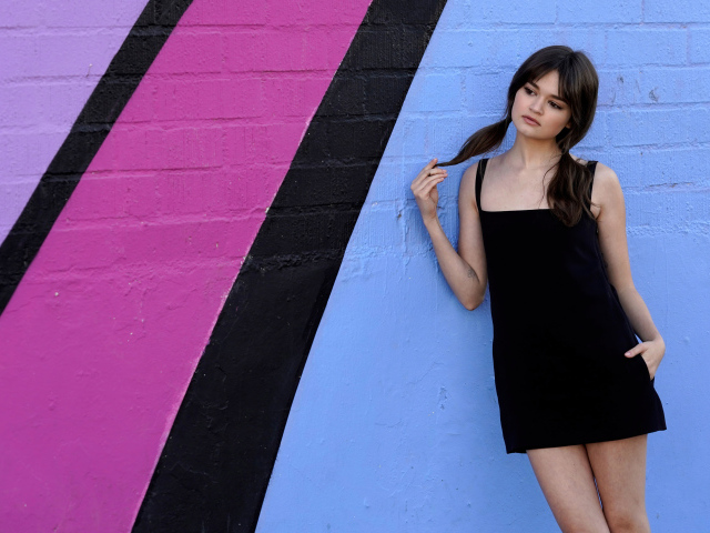 Милая девушка актриса Сиэра Браво у разноцветной стены