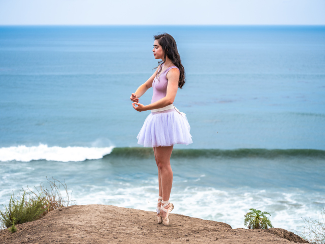 Девушка балерина занимается на берегу океана