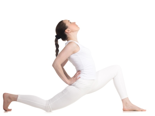 Девушка в белом костюме делает растяжку