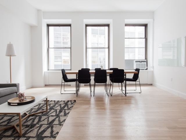 Большой стол с черными стульями в гостиной у окна 