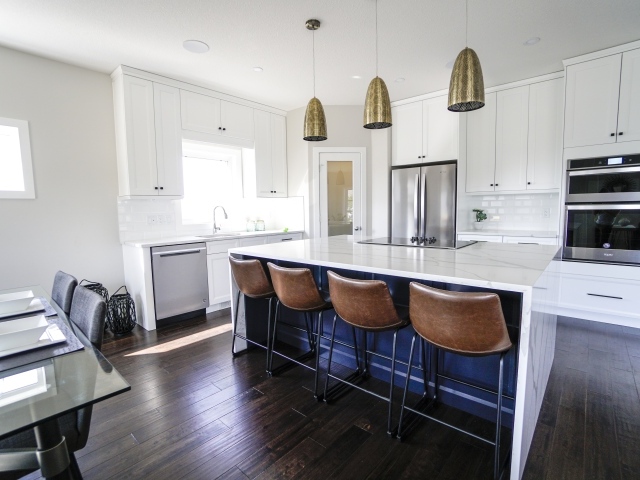 Кожаные кресла в большой кухне с белыми стенами