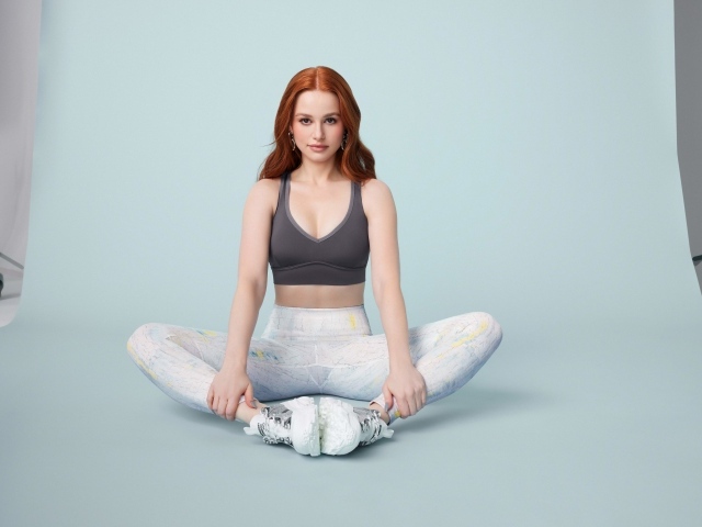 Рыжеволосая американская актриса Мэделин Петш сидит в позе лотоса