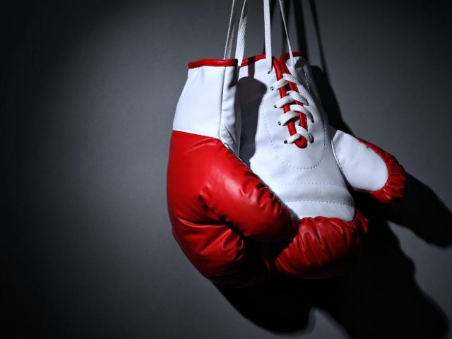 Красные боксерские перчатки на сером фоне