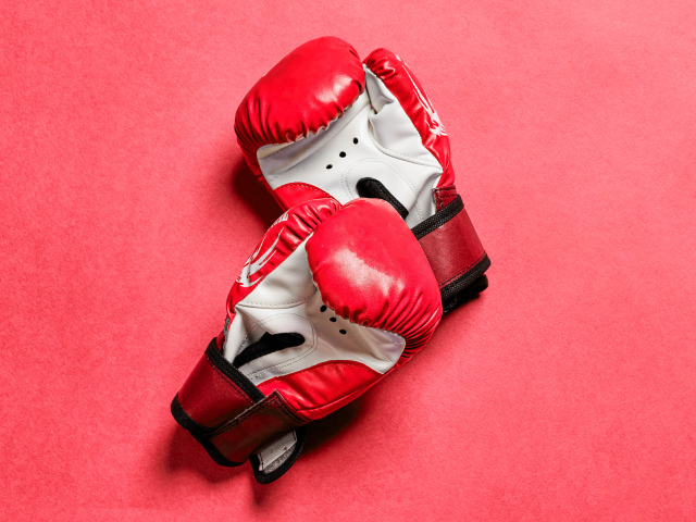 Красные боксерские перчатки на розовом фоне 