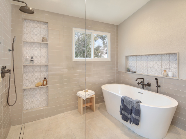 Душевая комната с белой ванной и серыми стенами