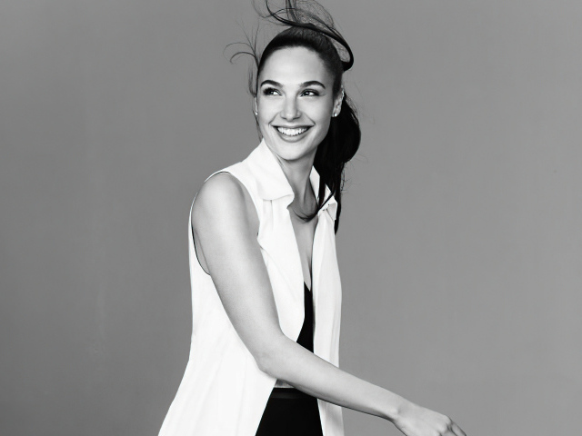 Улыбающаяся актриса Галь Гадот на сером фоне