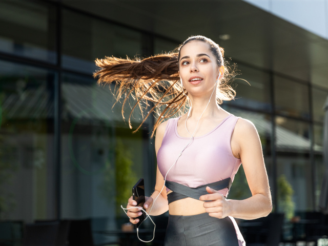 Спортивная девушка занимается бегом на улице