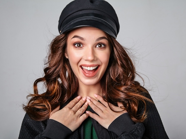 Удивленная кареглазая девушка в черной кепке