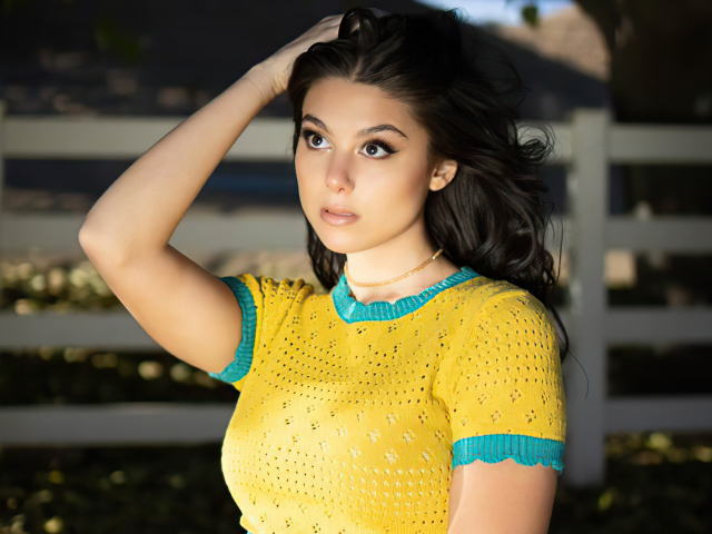 Молодая американская актриса Кира Косарин с рукой в волосах