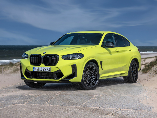 Желтый автомобиль BMW X4 M Competition 2021 года на фоне моря
