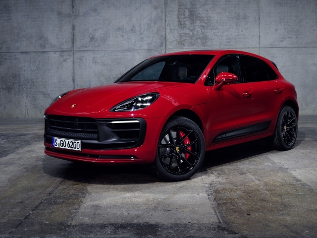 Красный автомобиль Porsche Macan GTS 2021 года на сером фоне