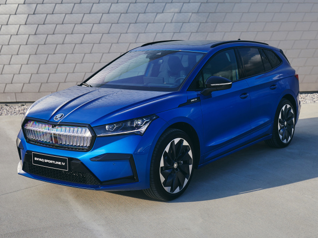 Синий автомобиль Skoda Enyaq Sportline IV 2021 года у стены