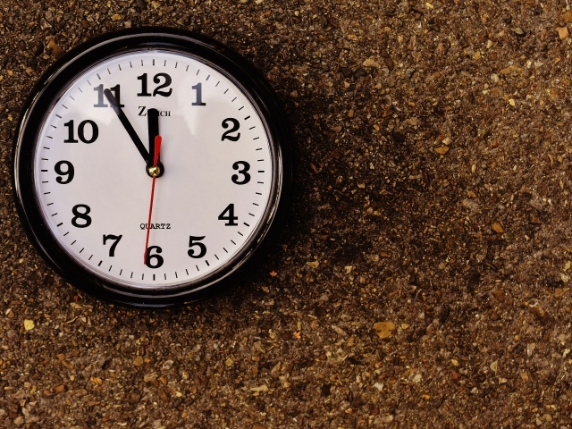 Большие черные часы висят на стене 