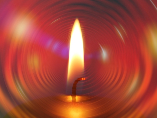 Огонь свечи на фоне красного круга 