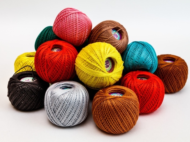 Разноцветные клубки пряжи на белом фоне 