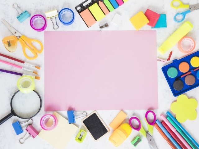 Лист бумаги, краски и канцелярские предметы на столе 