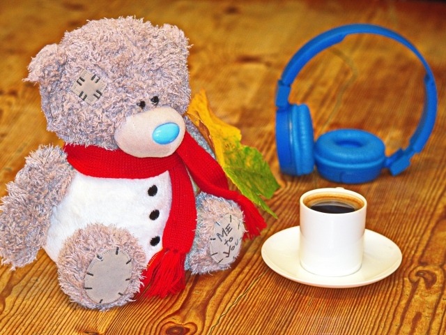 Игрушечный медведь с наушниками и чашкой кофе