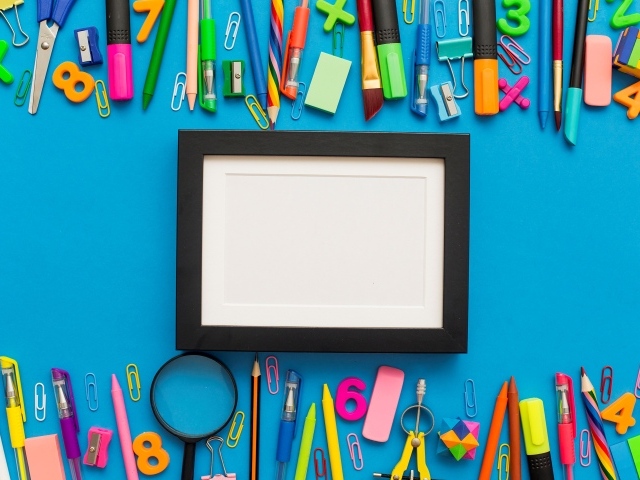 Белая рамка с разноцветными канцелярскими предметами на голубом фоне