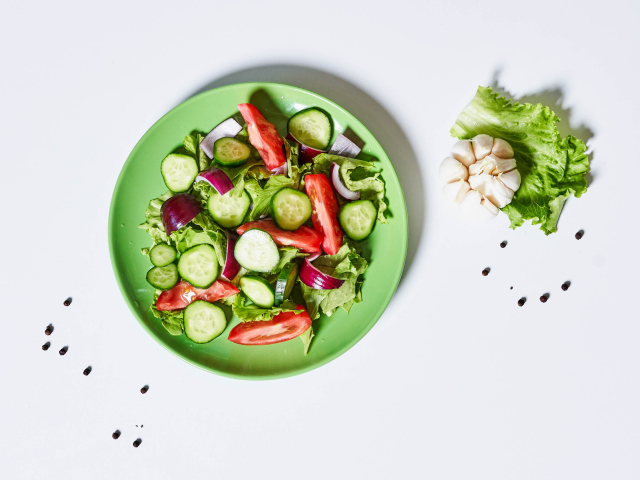 Салат с огурцами, луком, помидорами и листьями салата