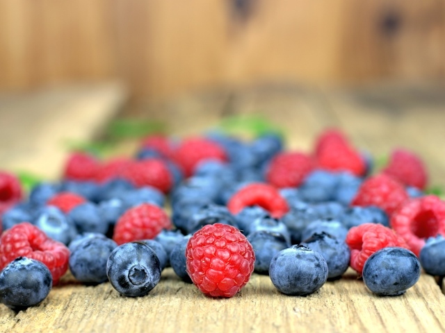 Свежие ягоды черники и малины на лавке