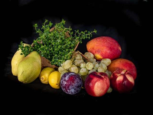 Свежие фрукты с зеленью на черном фоне 
