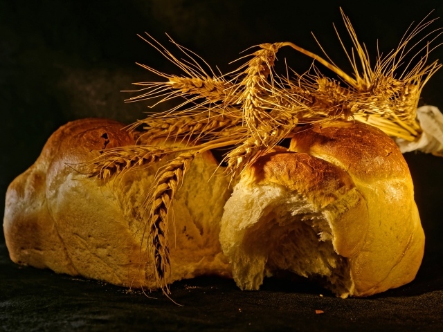 Свежий хлеб с колосьями пшеницы на столе