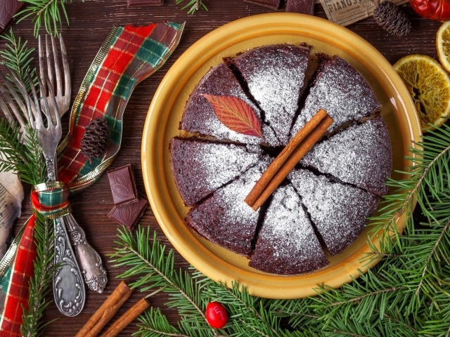 Пирог с сахарной пудрой на столе со столовыми приборами