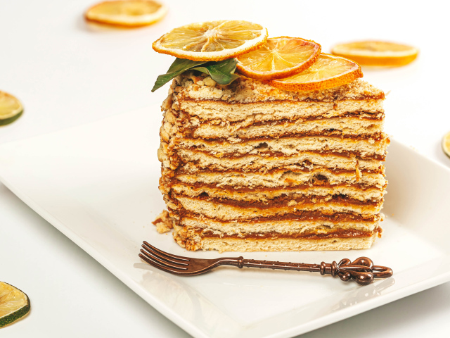 Кусок торт с сушеными лимонами на белой тарелке